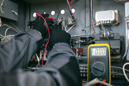 Electrician is checking the voltage in the electrical circuit of the installation with a multimeter...
