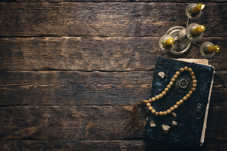 Ancient magic book and burning candle on a wooden table background with copy space. Spellbook.の写真素材