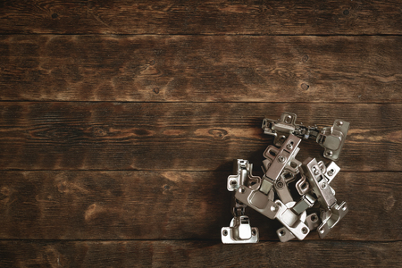 Door hinges on a wooden table background with copy space. Furniture maker table.の写真素材