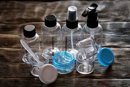 Various plastic empty cosmetic bottles and jars on a wooden table abstract background.の写真素材