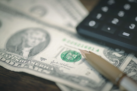 Calculator and a few dollars on a table.. Tight of money. Lack of money. Financial problems. Bankrupt. Pay the debts concept.の写真素材