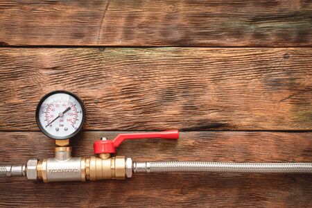 Plumbing flat lay background with copy space. Water pressure meter on the pipeline with valve.