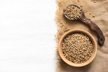 Malt in a wooden bowl on the white kitchen table background.の写真素材