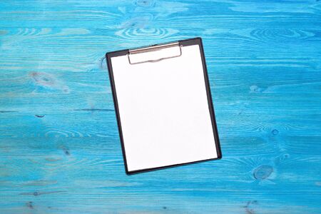 Blank document page on blue wooden table background.