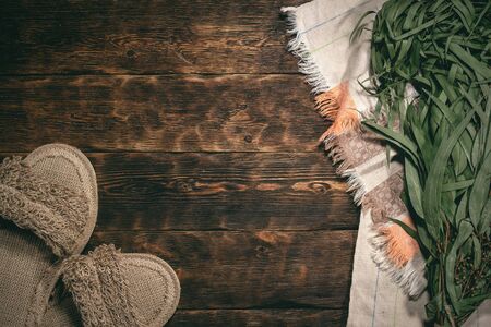 Eucalyptus bath broom, bath slippers and a towel on a bathhouse table flat lay background with copy space.の写真素材