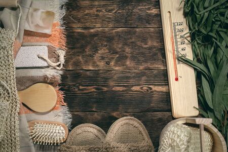 Eucalyptus bath broom and other bathhouse accessories on a wooden table flat lay background with copy space.の写真素材