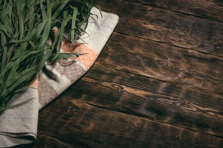 Eucalyptus bath broom and a towel on a bathhouse table flat lay background with copy space.の写真素材