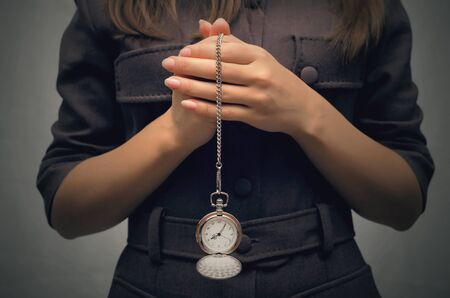 Business woman holding in hands pocket watch. Time is money concept. Being late to work concept....