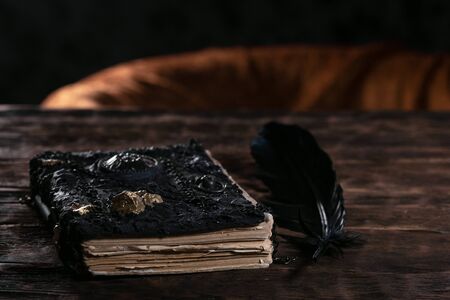 Ancient magic book on a wooden table background. Spellbook.