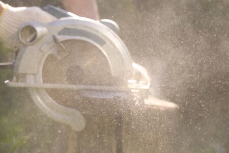 Man is cutting a wooden bar by a circular. Woodwork.の写真素材