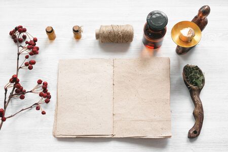 Recipe magic book and various dry herbs on a table of witch doctor or a herbal medicine essential oil on a table.の写真素材