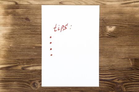 Tips note paper page with copy space on wooden desk table surface background.の写真素材
