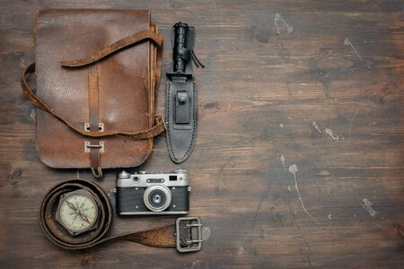 Old travel equipment and adventurer accessories on the wooden table flat lay background.の写真素材