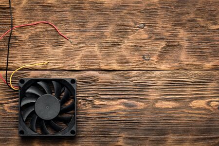 Old CPU fan on a brown wooden table background with copy space.