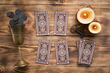 Tarot cards and golden goblet on brown table of fortune teller. Divination. Future reading concept.の写真素材