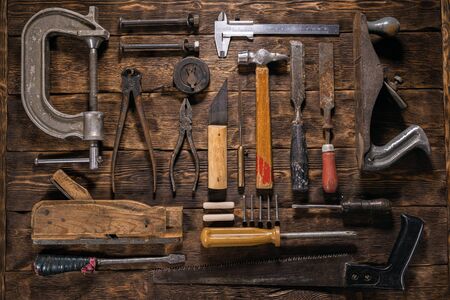 Old carpentry work tools on a brown wooden table background.の写真素材