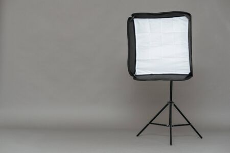 Studio softbox on a tripod on a gray background with copy space.の写真素材