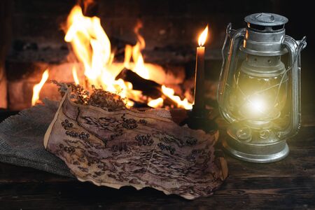 Pirate treasure map and kerosene lamp over a burning fire background. Treasure hunt concept.の写真素材