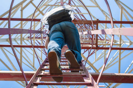Cell tower service specialist is up on the staircase.