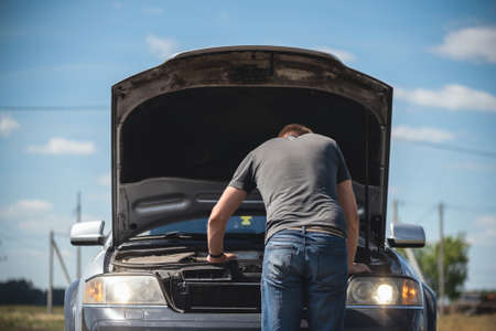 Driver open a hood of broken car.