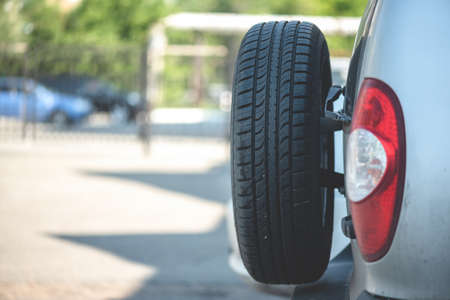 Spare wheel on the trunk of an offroad car close up.の写真素材