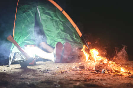Legs of sleeping tourist is sticking out from the tent.