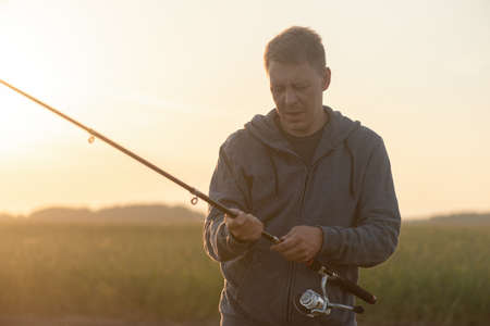Fisher with fishing rod outdoors.の写真素材