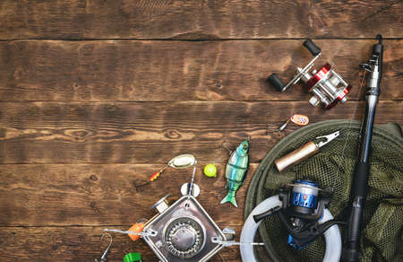 Fishing flat lay background with a copy space. Fishing gear on a wooden table.
