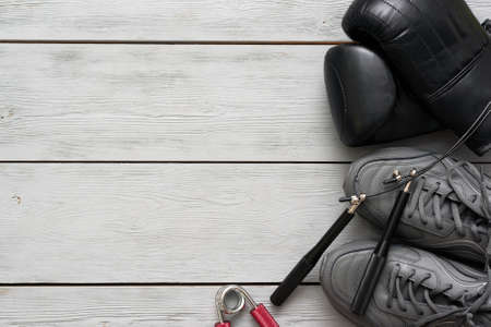 Boxing gloves, sport shoes and jumping rope on a wooden flat lay background with copy space.の写真素材
