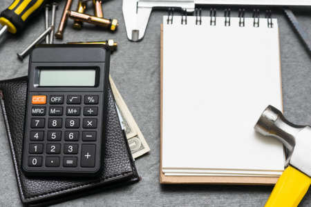 Construction cost or repair calculation mockup. Blank page notepad and work tools on the workbench.の写真素材