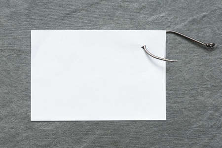 Blank paper page on the fishing hook on the table flat lay background. To do list.の写真素材