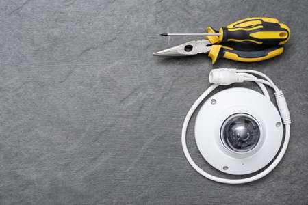 Security camera, pliers and screwdriver on the dark flat lay background with copy space.の写真素材