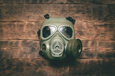 Gas mask on the old wooden table background.の写真素材