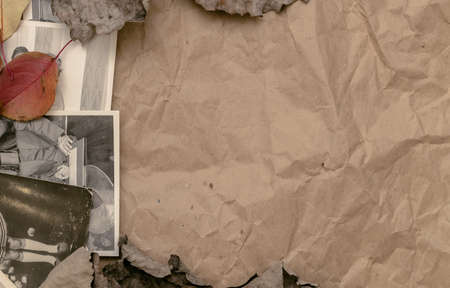 Old vintage photos of peoples with no faces and autumn foliage on crumpled paper page background...
