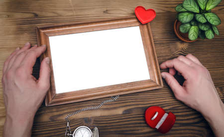 Photo frame with copy space in male hands and wedding ring in a present box. Declaration of love....