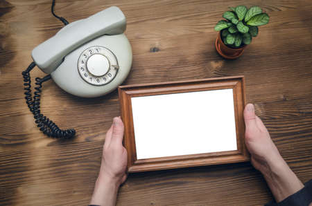 Phone and photo frame with copy space in male hands. Business diploma or certificate mock up. Family...