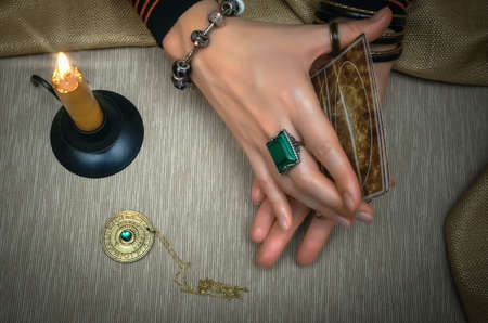 Tarot cards on fortune teller desk table. Future reading. Woman fortune teller holding in hands a...