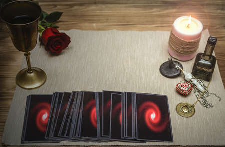 Tarot cards and rose flower on fortune teller desk table background. Future reading. Love or...