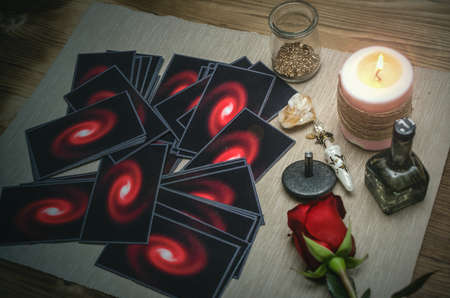 Tarot cards and rose flower on fortune teller desk table background. Future reading. Love or...