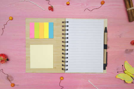 Blank paper page note pad on purple decorated by small toy berry and cinnamon sticks wooden desk...