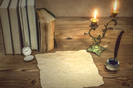 The old letter. Old books feather pen in inkpot, blank paper page sheet and retro pocket watch on...