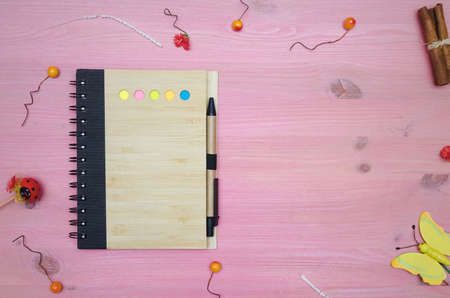 Blank paper page note pad on purple decorated by small toy berry and cinnamon sticks wooden desk...