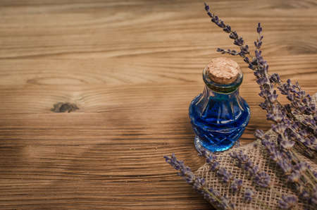 Herbal medicine. Alternative medicine concept. Dry organic natural ingridients. Healing tincture beverage and dry lavender branches on the table.の写真素材