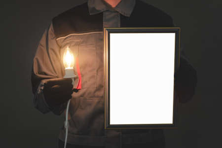 Electrician with a blank picture frame border and burning lightbulb in the dark. Best electrician diploma template.の写真素材