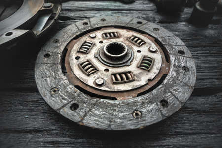 Old car clutch disk on the black workbench background.の写真素材
