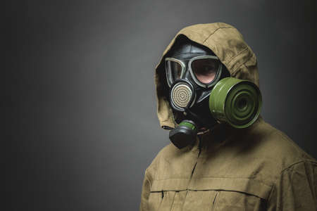 Man in gas mask close up on gray background.の写真素材