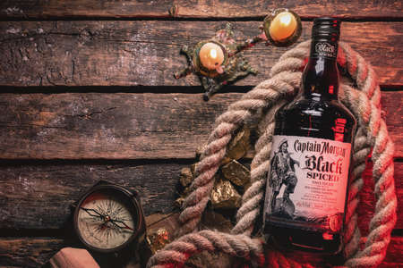 Moscow, Russia 25 June 2020: Luxury rum the Captain Morgan black spiced on the old wooden table...