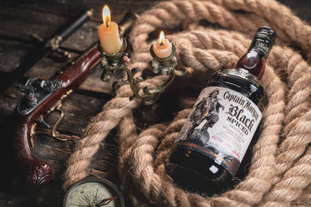 Moscow, Russia 25 June 2020: Luxury rum the Captain Morgan black spiced on the old wooden table...