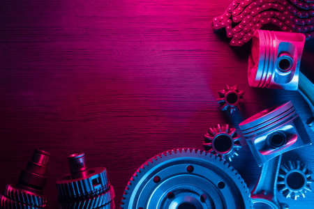 Disassembled car gearbox parts and engine pistons on the car service workbench flat lay background.の写真素材