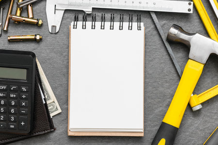 Construction cost or repair calculation mockup. Blank page notepad and work tools on the workbench.の写真素材